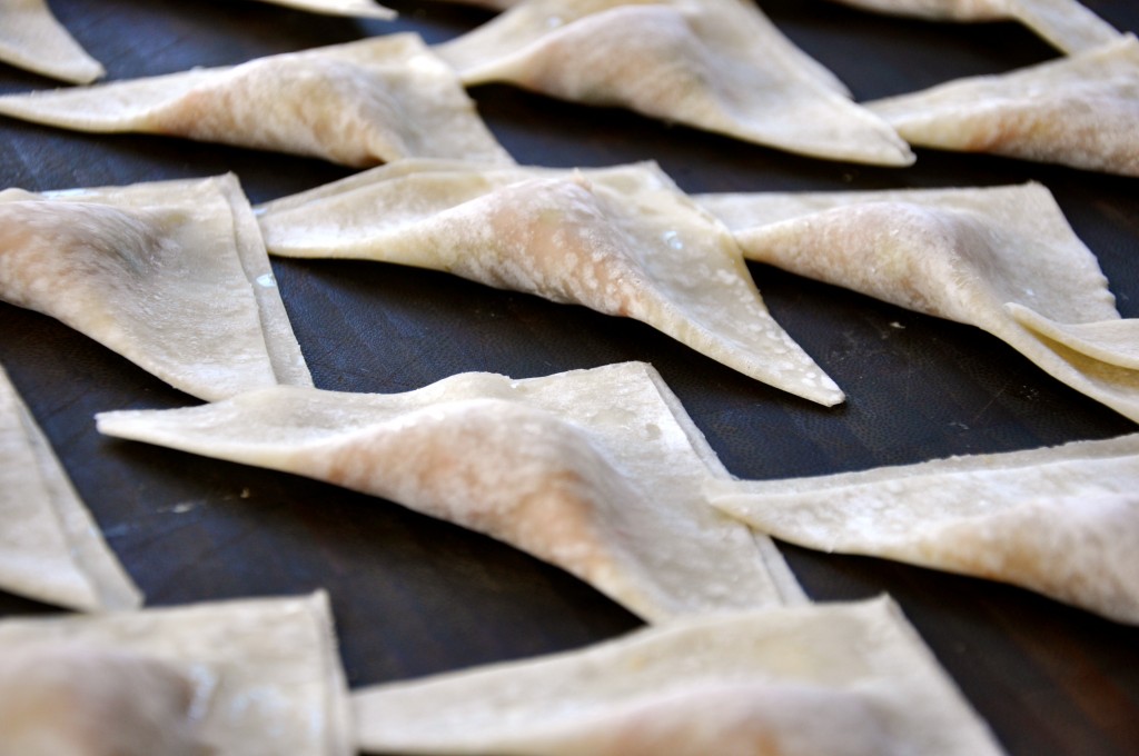 triangular wontons on a tray pre-cooked