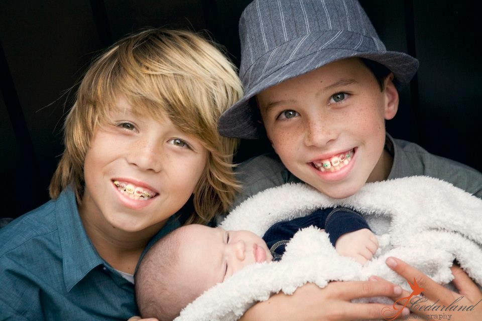 blond surfer kid, brunette skater kid, and their baby brother