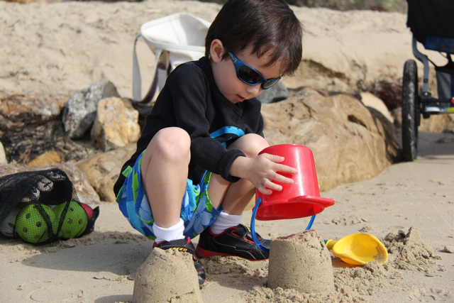 preschooler digging in sand at the beach