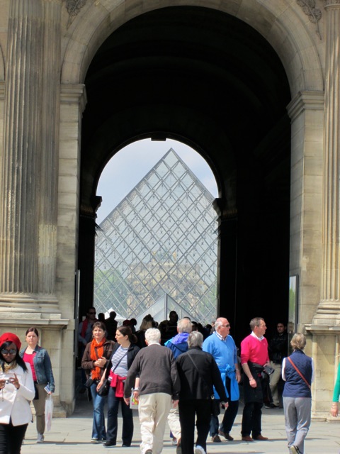 view of Louvre pyramid through arched walkway