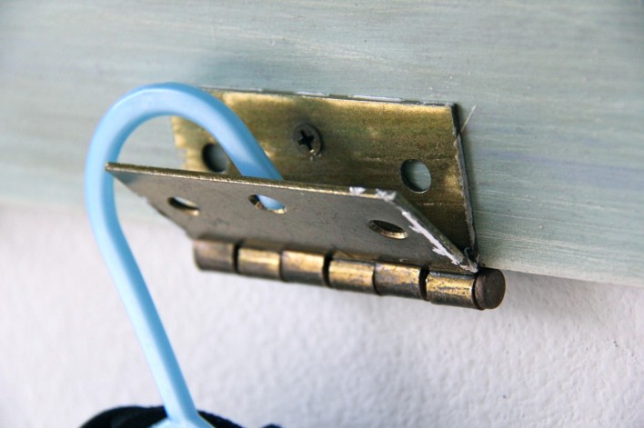 closeup of old hinge holding a hanger 