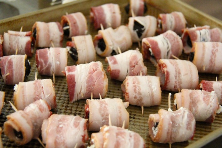 feta stuffed dates wrapped in bacon lined up on baking sheet