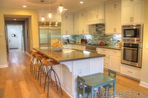 beachy kitchen with darn quartz and blue stacked tile back splash white shaker cabinets