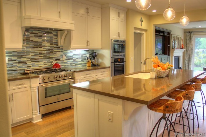 beachy kitchen with darn quartz  and blue stacked tile back splash white shaker cabinets