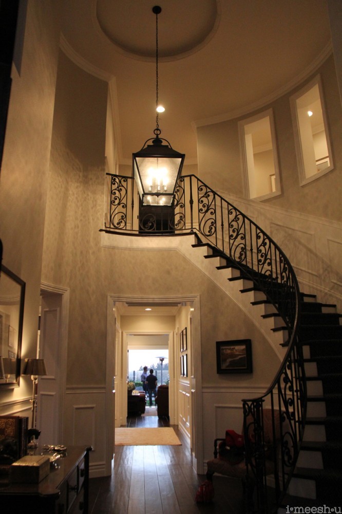 grandiose front entry sweeping curved wrought iron staircase
